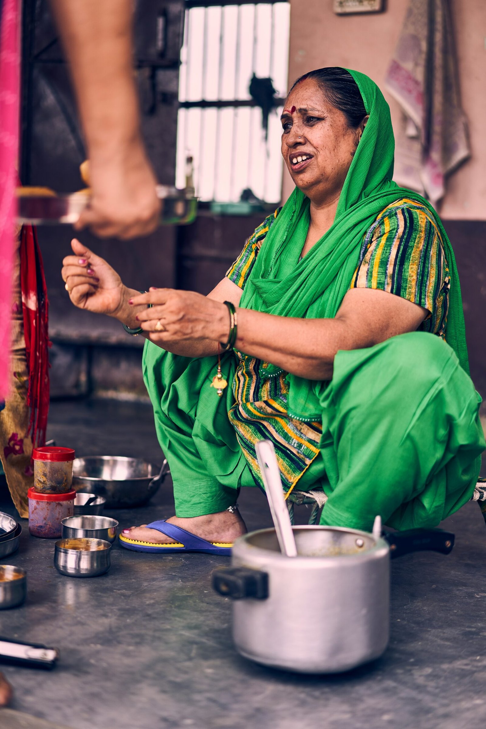 man in green and yellow traditional dress sitting on blue table